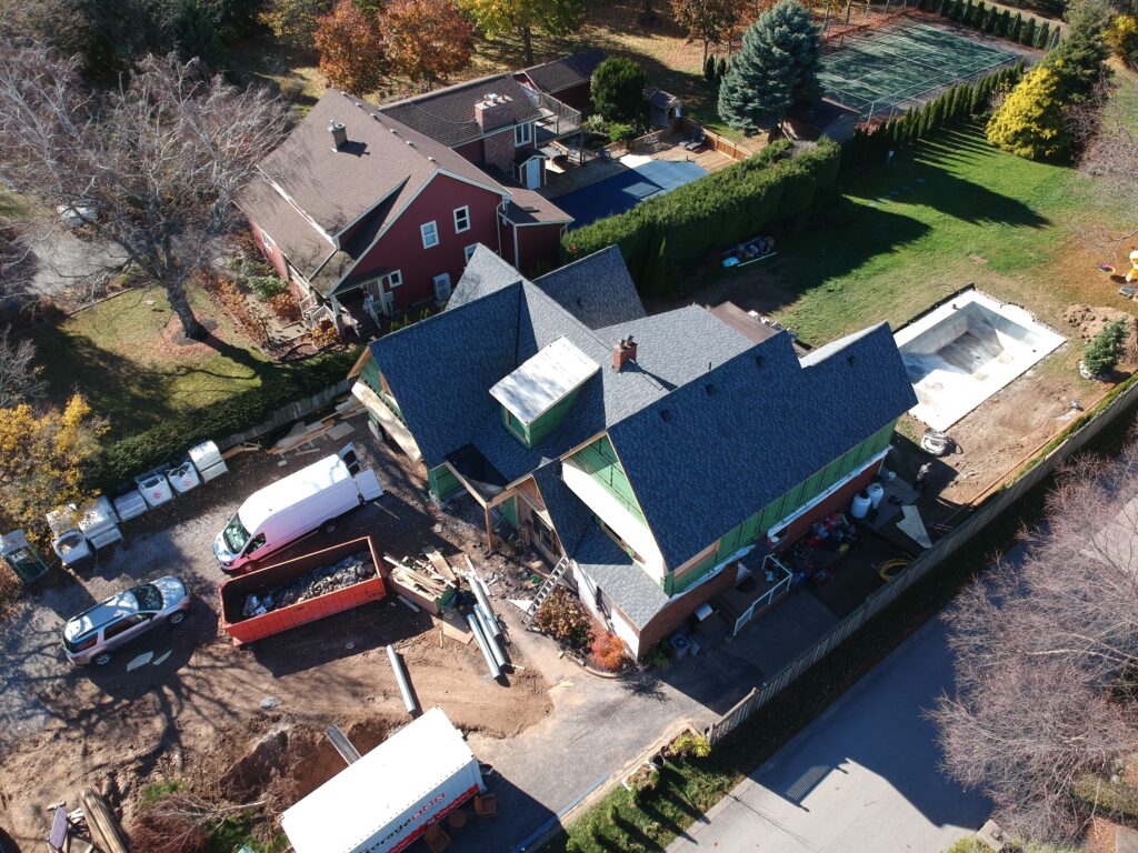 Aerial view of a two-storey home with a new dark shingle roof