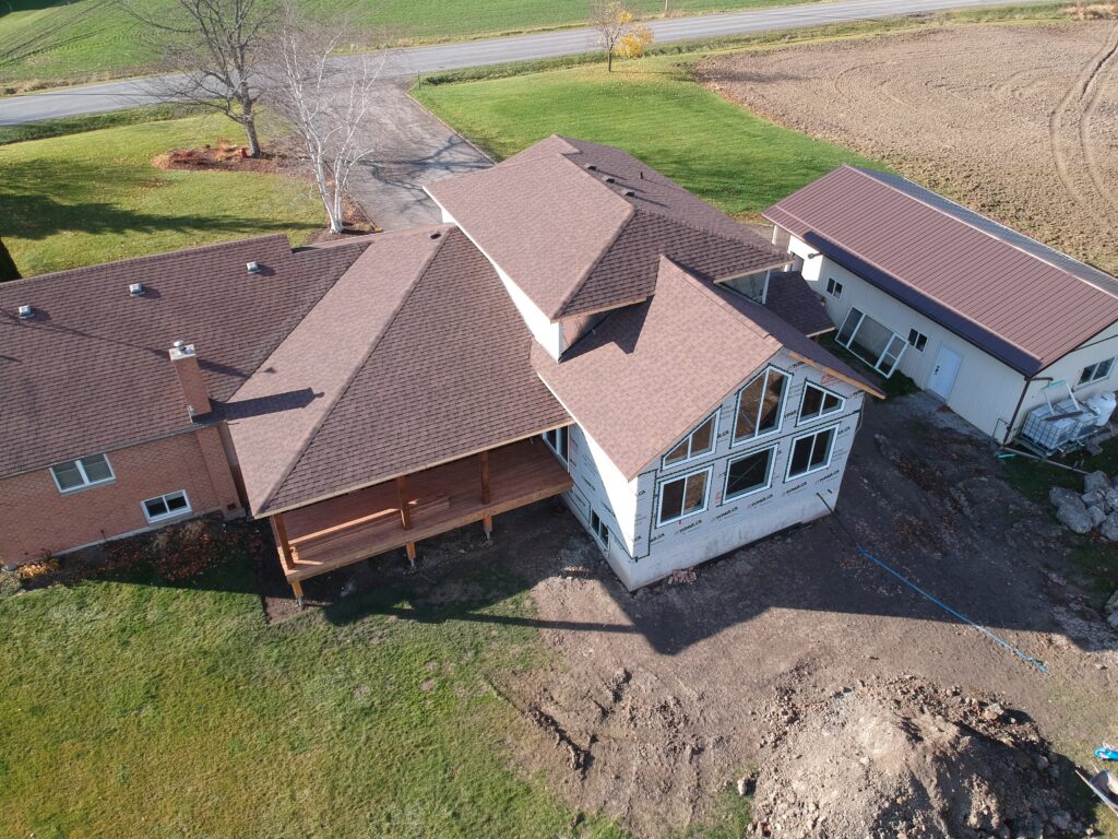 Country home in West Lincoln with new brown architectural shingles on the main house and addition