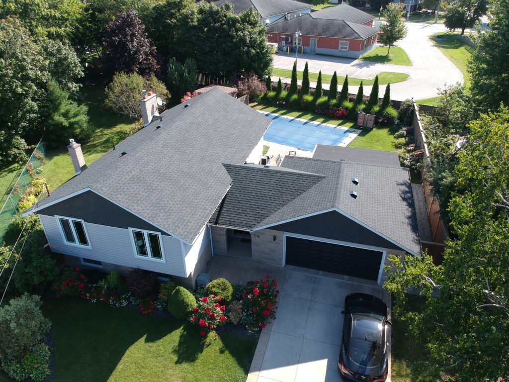 Smithville home with a new charcoal shingle roof, viewed from above beside an in-ground pool