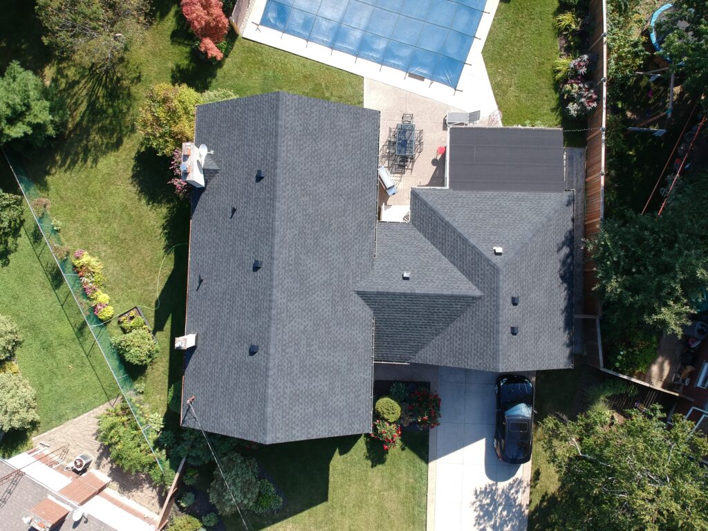 Aerial view of a Smithville home with a new charcoal asphalt shingle roof beside a backyard pool