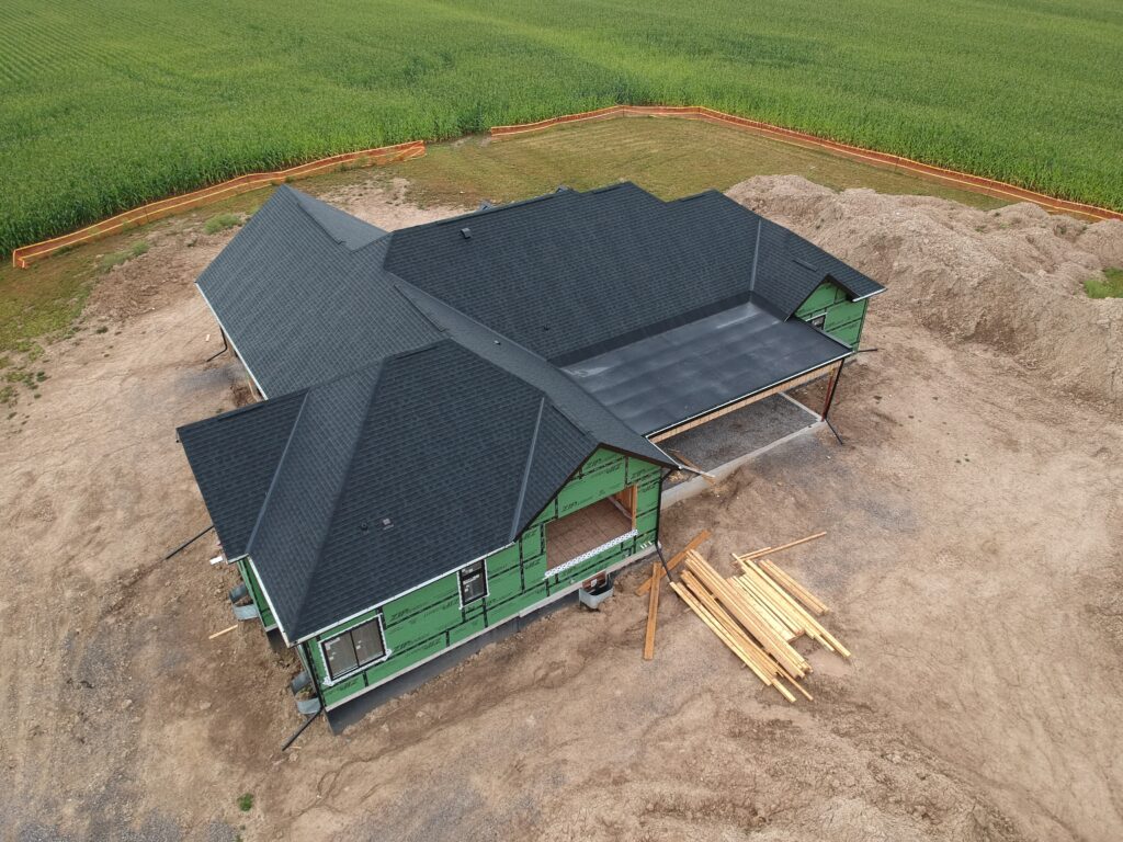 New-build home with a freshly installed dark shingle roof