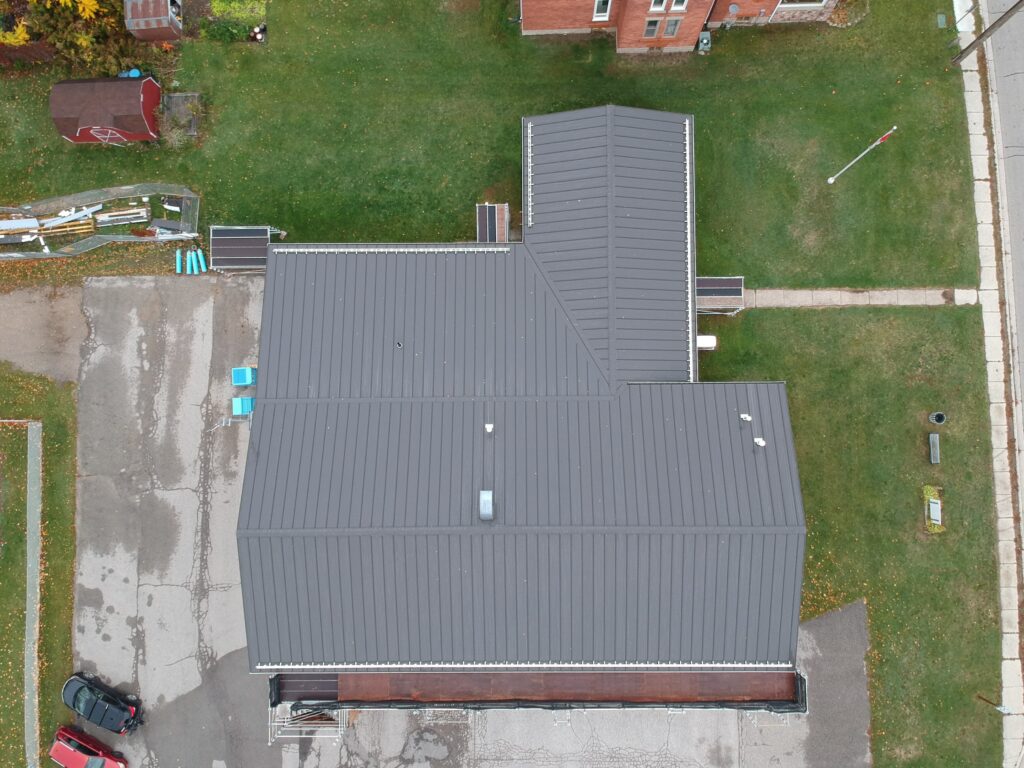 Rural home with a new shingle roof, aerial view