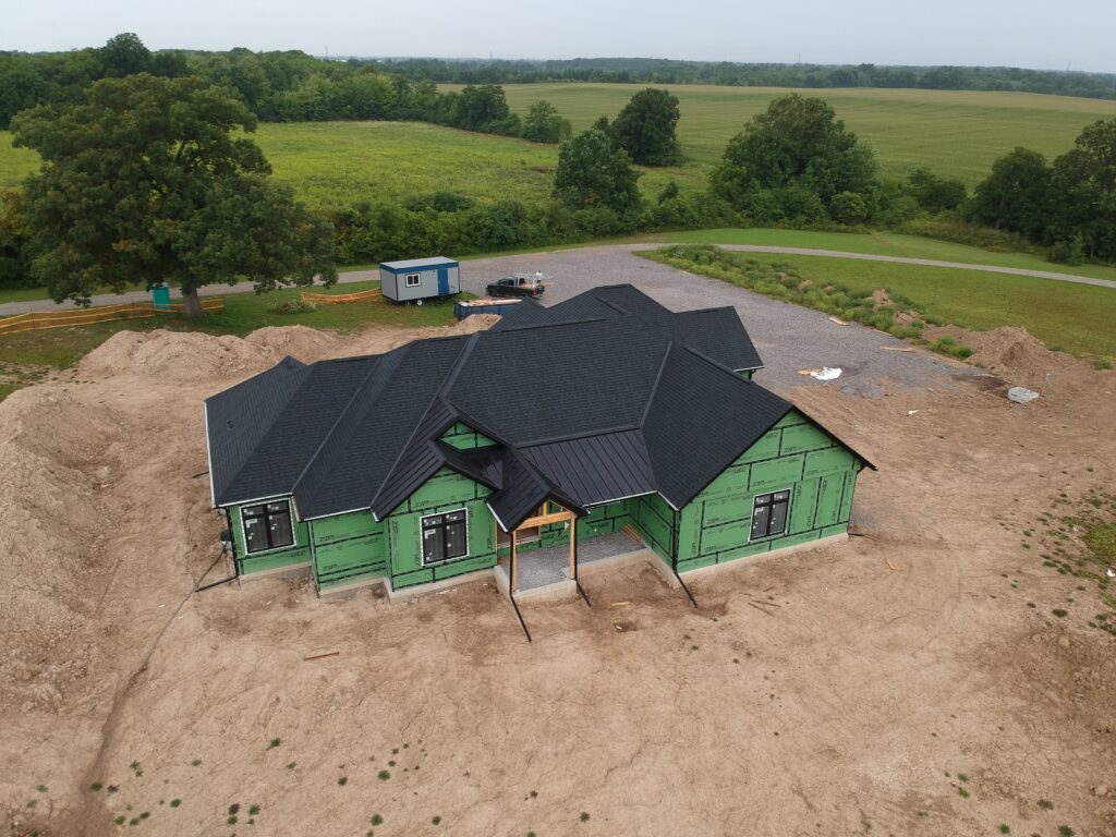 New-build rural home with a black shingle roof