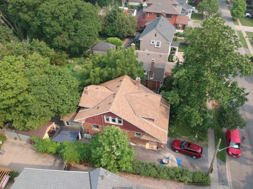 Aerial view of a red brick home in an established St. Catharines neighbourhood with a new tan shingle roof