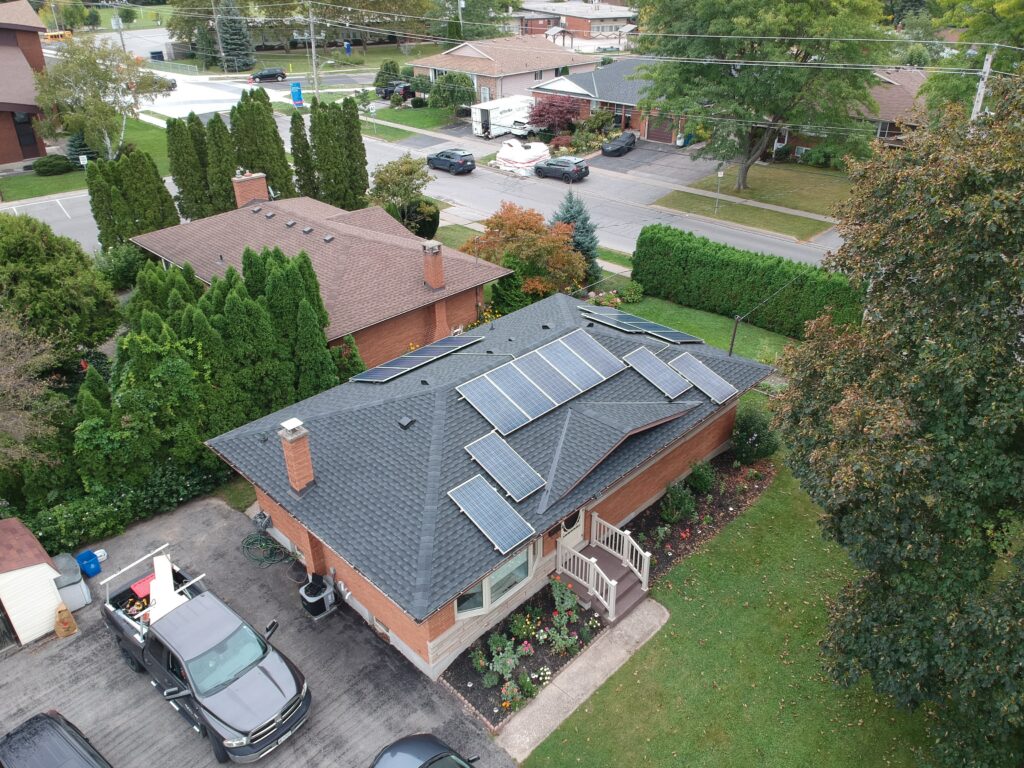 St. Catharines home with solar panels on a new dark grey shingle roof, aerial view